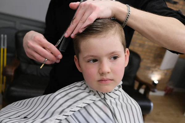 Un niño pequeño se recorta en los peluqueros emociones brillantes —  Fotos de Stock