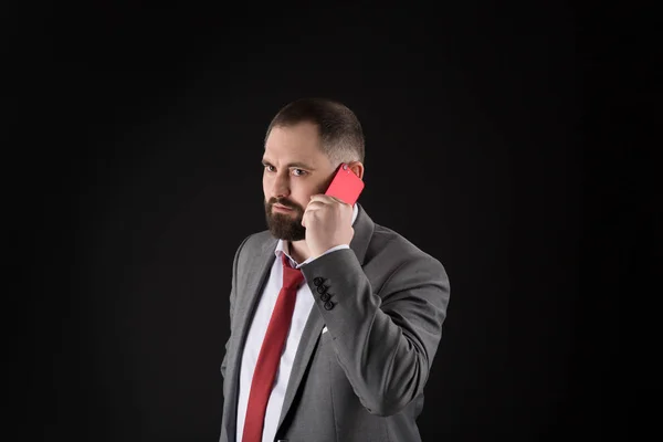 Guy chiama amico stand sfondo nero. Concetto di chiamata mobile. Un uomo vestito formale chiama qualcuno. Conversazione di telefonate. Negoziati mobili. Uomo d'affari ben curato uomo maturo tenere smartphone . — Foto Stock