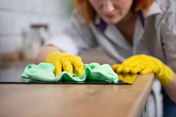 Vrouw schoonmaken inductie top, hand in gele rubberen handschoen polish kachel kookplaat, close-up, geen gezicht. helder keukenapparaat — Stockfoto