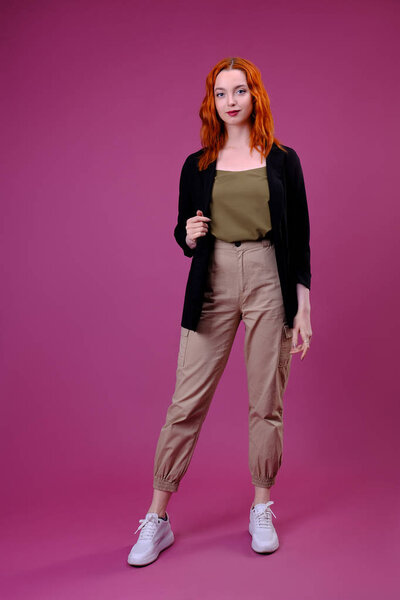 Модный студийный портрет молодой женщины на розовом фоне
