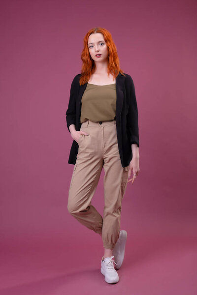 Привлекательная молодая рыжая женщина смотрит в камеру
