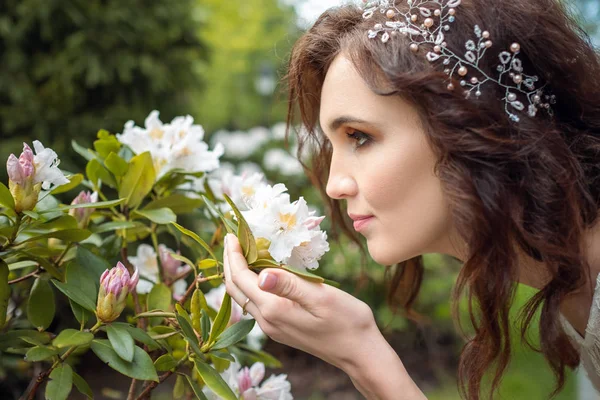 Woman in wreath smelling flowers on a branch — 스톡 사진