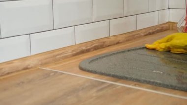 Mutfak lavabosu temizliği. Sarı lastik eldivenli kadın mutfak lavabolarını yıkıyor. Sarı lastik eldivenli kadın mutfak lavabosunu yıkıyor.