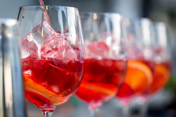 Glazen cocktails op de bar. barman giet een glas mousserende wijn met Aperol. — Stockfoto