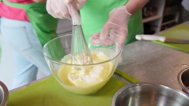 Primer plano de mano de las manos de cocinero en guantes de goma blanca mezclando mantequilla con azúcar batidor celebración — Vídeo de stock