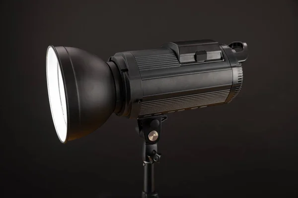 Hoofd van Studio Flash strobe lamp licht. Zijaanzicht professionele studio fotografie verlichting close-up op zwarte achtergrond. — Stockfoto