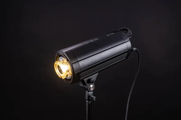 Hoofd van Studio Flash strobe lamp licht. Zijaanzicht professionele studio fotografie verlichting close-up op zwarte achtergrond. — Stockfoto