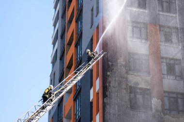 ateş ile su hortumu extinguish için bir merdiven tırmanma itfaiyeci