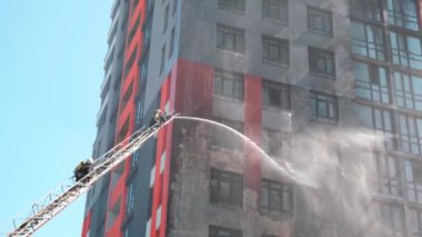 Kiev, Ukrayna, 31.08.2019. Pikap merdivende iki itfaiyeci yanan çok katlı binada yangın söndürme