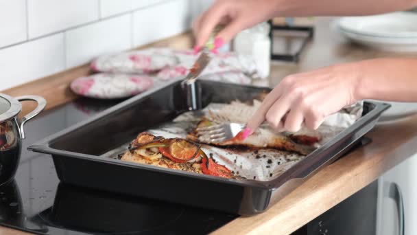 クックは調理された魚をカットし シェフが調理したマスの魚を包丁で切るクローズアップ 調理プロセス — ストック動画