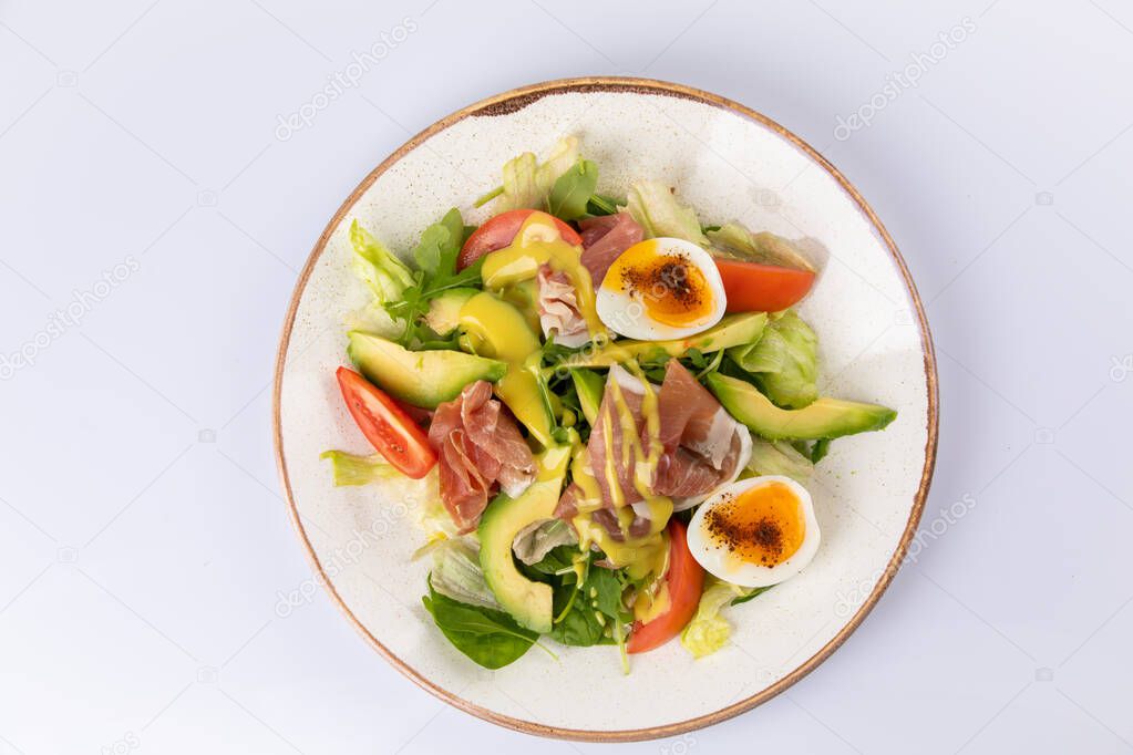 Healthy breakfast. Salad with prosciutto, tomato, egg, avocado