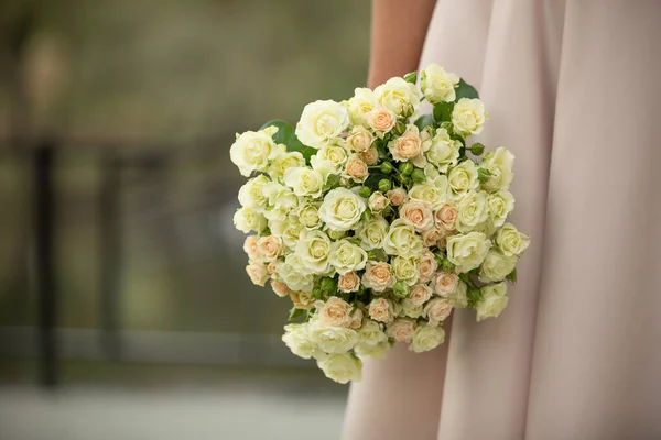 La mariée tenant le bouquet de mariage de roses roses et blanches — Photo