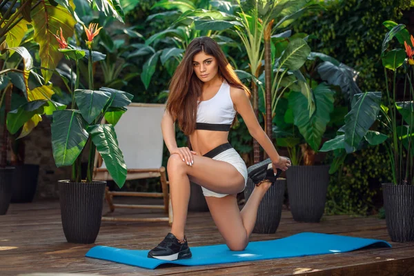 Mujer haciendo yoga en un parque tropical en el resort vocacional — Foto de Stock