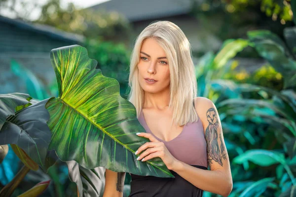 Portret de vară de femeie senzuală sexy uimitoare, pozând la un hotel de lux lângă plantele din junglă, purtând îmbrăcăminte sport — Fotografie, imagine de stoc