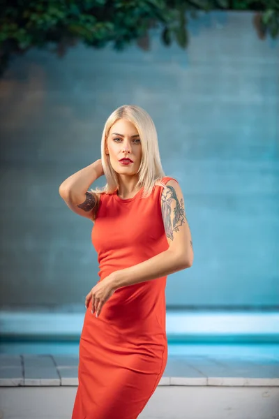 Moda plenerowa Fotografia pięknej seksownej kobiety z blond włosami w luksusowej sukni pozowanie obok basenu — Zdjęcie stockowe
