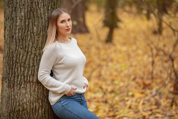 가을 공원을 걷고 있는 향수에 젖은 젊은 여자 — 스톡 사진