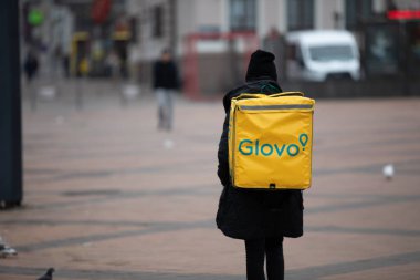Ukrayna Glovo 'nun teslimat kuryesi. Ukrayna, Kiev 'de teslimat servisi, 9 Mar 2020. Arka görüş, hareket bulanıklığı