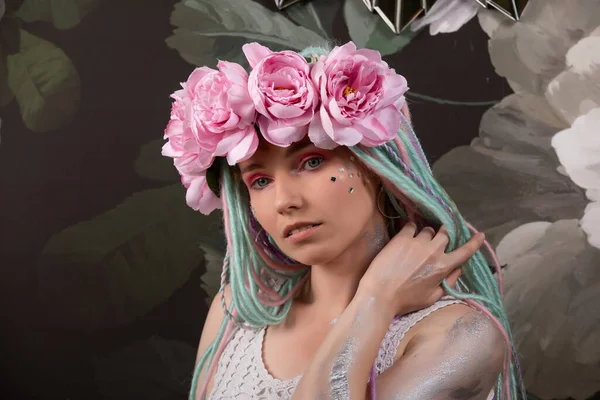 Πορτρέτο της γυναίκας με φωτεινά χρώματα dreadlocks. γυναίκα σε φόντο λουλουδιών. γυναίκα με ένα στεφάνι από ροζ τριαντάφυλλα — Φωτογραφία Αρχείου