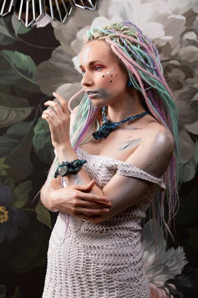 Portrét ženy s pestrobarevnými dredy. žena na květinové pozadí — Stock fotografie