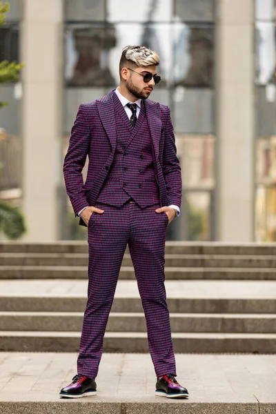 眼鏡をかけ髭を生やした若い実業家が階段を降りる 紫の豪華な3ピースのスーツを着た男 — ストック写真