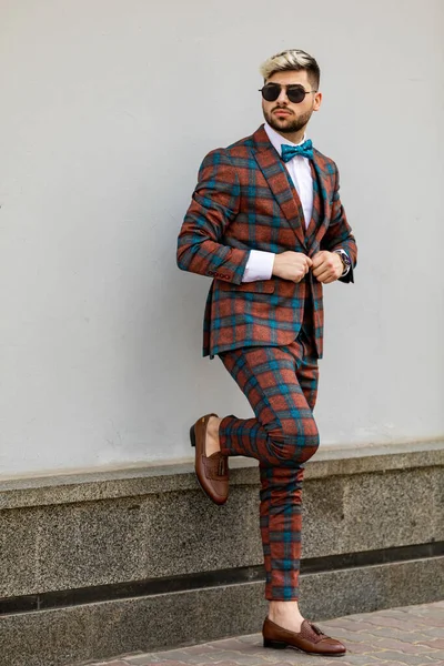 若い実業家が腕時計の時刻を調べている ストリートを歩く豪華なチェックスーツを着た男 — ストック写真