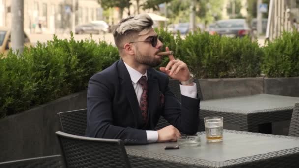 Κακός Επιχειρηματίας Καπνίζει Πούρο Και Πίνει Ουίσκι Ουίσκι Στη Βεράντα — Αρχείο Βίντεο