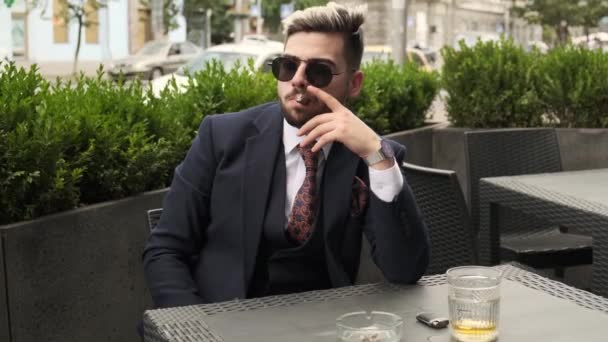 Σοβαρός Επιχειρηματίας Καπνίζει Πούρο Και Πίνει Ουίσκι Ουίσκι Στη Βεράντα — Αρχείο Βίντεο