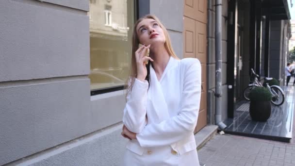 Retrato de mulher excitada falando telefone celular na rua da cidade. Closeup menina feliz usando smartphone em fundo urbano. Mulher emocional chamando celular ao ar livre . — Vídeo de Stock