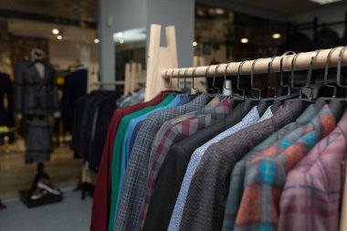 Pahalı erkek giyim mağazası. Askıda bir sıra ceket. Mağaza satış arka planı teması. Erkek giysileri mağazada askıda.