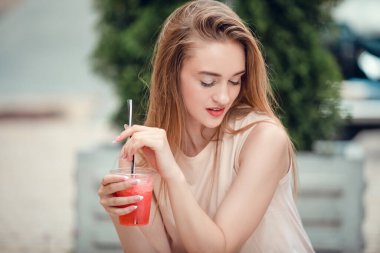 Açık hava moda güzellik portresi zarif, muhteşem uzun saçlar, lezzetli soğuk kokteyller içmek, şehir kafesi terası, seyahat, neşe, rahatlama. Sıcak yazda susuzluğunu gider.