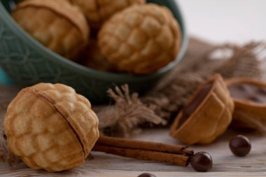 Lezzetli ceviz biçimli kurabiye. Yoğunlaştırılmış tatlı süt ve tarçınlı kurabiye. Eski ahşap kumaş arka planda.