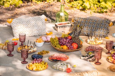 Plaj konseptinde romantik akşam yemeği pikniği. Yemek, kahve, battaniye ve yastık. Doğadaki arkadaşlar için dinlenme zamanı.
