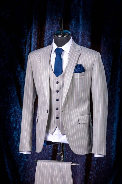 mens business suit on a dummy. elegant three-piece suit with a vest, tie and pocket square