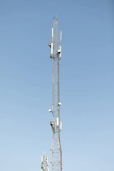 Mast or tower for mobile phone communication in bright sunshine and blue sky. Relay tower internet 4G comunication