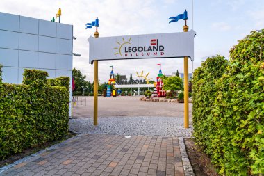 Danimarka 'nın Billund kentindeki canlı Legoland girişine, güneşli bir günde yeşil alanla çevrili yaya yolu portala ve kareye yaklaşıyor..