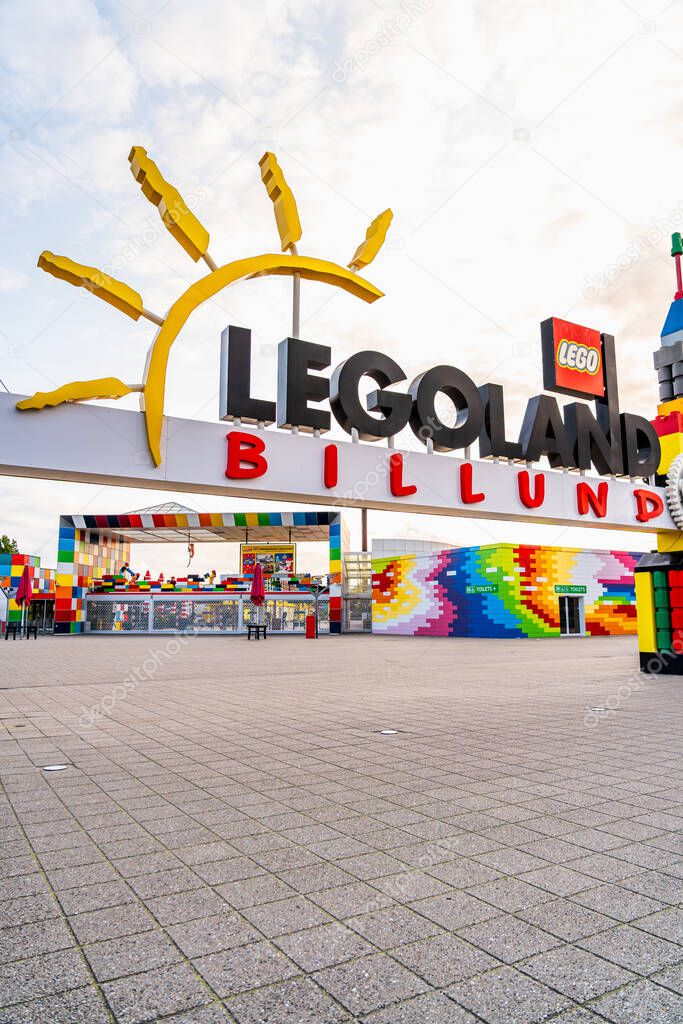 A vibrant Gateway and entrance adorned with colorful structures welcomes visitors to Legoland Billund. The empty square offers a serene view during a warm summer evening after closing time.