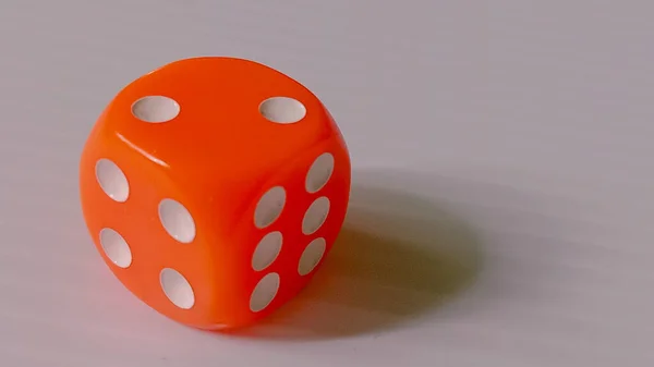 Beş numarayı gösteren tek turuncu zarlar, minimum bir yüzey üzerinde duruyor..