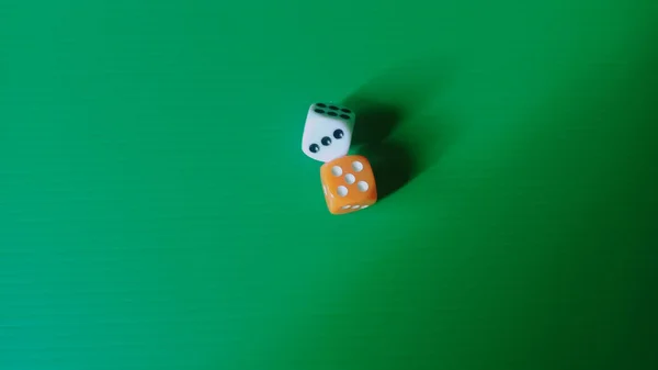 Bu, canlı yeşil dokulu arka planda, dinamik ve istiflenmiş bir düzende iki tane altı taraflı zar yakalayan bir fotoğraf..