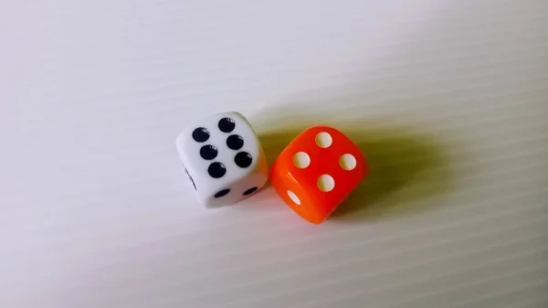 Bu, düz beyaz arkaplan ve ince doğrusal dokuya sahip iki adet altı kenarlı zarın net ve yakın plan fotoğrafı..