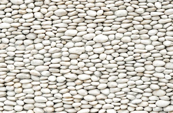 Natural backgrounds of white stones with round shape on the wall use for decoration in the garden outdoors.