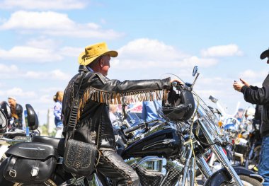 Dnipro city, Ukrayna, 28 Nisan 2018 adam şık deri ceket ve sarı bir şapka dik bir motosiklet üzerinde oturuyor. Moto sezon açılış Dnepr şehirde (Dnepropetrovsk), Ukrayna