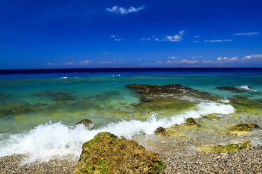 Güzel yaz plaj, taş, çakıl ve dalgalar üzerinde bir güzel turkuaz deniz, Rhodes, Yunanistan