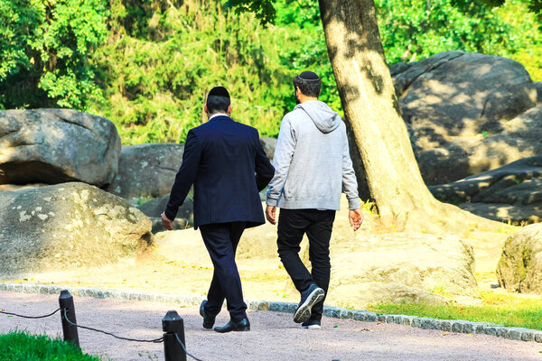 2 man, the Hasidim Jews are walking in the park in Uman, Ukraine, the time of the Jewish New Year, Rosh Hashanah