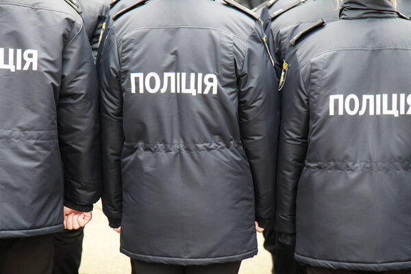 The policemen in uniform with the inscription Police in Ukrainian,  stand the street in Dnipro city, Dnepropetrovsk, Ukraine