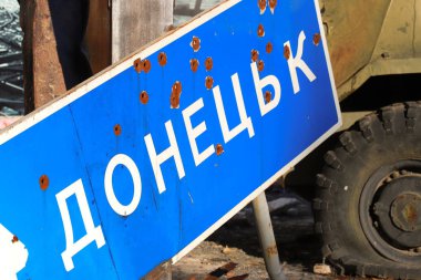 Yol işaret Donetsk, Ukrayna şehrin yumruk kursun Donbass, kırık askeri teçhizat karşı savaş sırasında çakışma Doğu Ukrayna