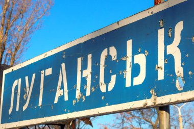 Road sign of the Ukrainian city of Lugansk, punched by bullets during the war in the Donbass, conflict East Ukraine clipart