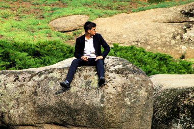 Uman, Ukrayna 23, 09 2017. Bir Yahudi Yahudi yeni yılı sırasında büyük bir taş Sofia parkta oturan bir genç Hassid adamdır.