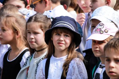 Dnipro City, Ukrayna 26.05 2018. Mavi şapkalı yorgun bir kız birinci sınıf bir okul tatili sırasında bir gösteri izliyor. Dnipropetrovsk