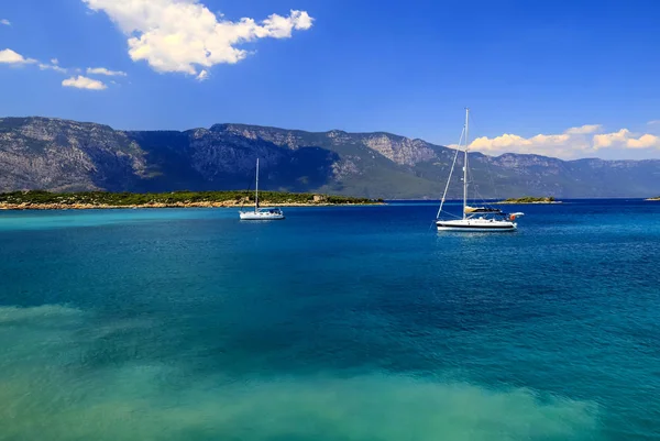 Güzel mavi denizde beyaz yatlar, seyahat, dinlenme ve tatil konsepti. Ege Denizi, Türkiye, Bodrum ve Marmaris yakınlarında 