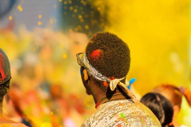 İlkbahar, yaz, Dnipro şehir, Ukrayna Holi festivalinde sarı boya arka planda eğlenmek renkli kaplı saç ile Afrikalı erkek öğrenci